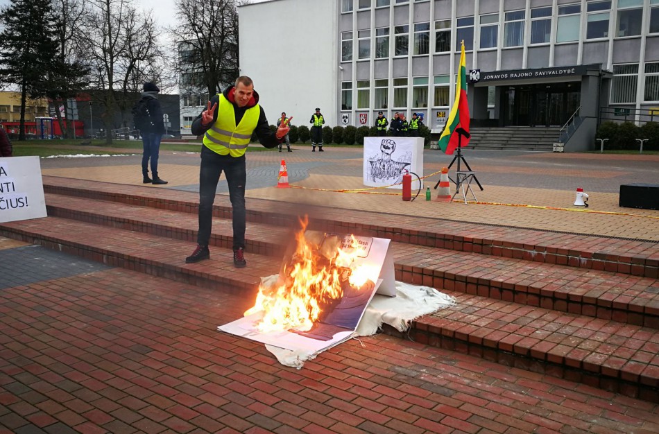 Piketas prie savivaldybės su degančiu plakatu