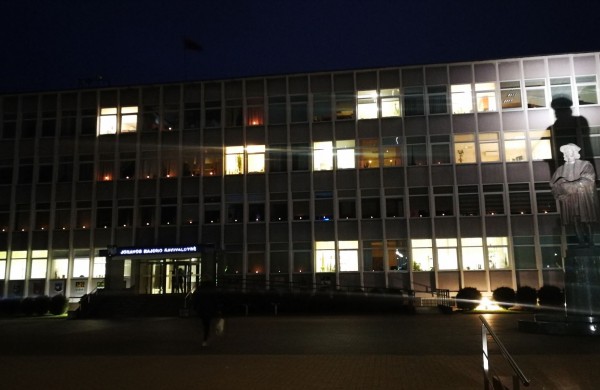 Žvakučių liepsna tamsiuose languose