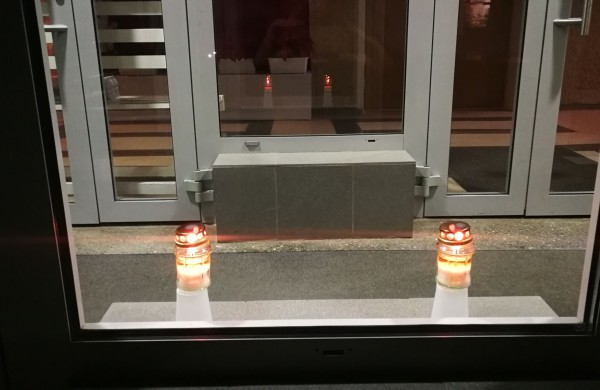 Žvakučių liepsna tamsiuose languose