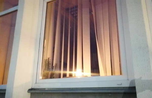 Žvakučių liepsna tamsiuose languose