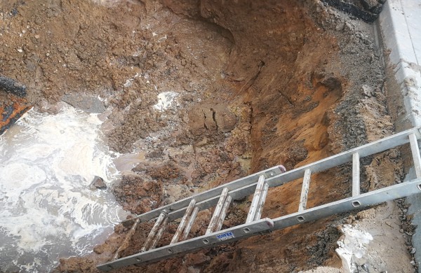 Dėl vandentiekio avarijos atsivėrusi smegduobė „prarijo“ automobilį 