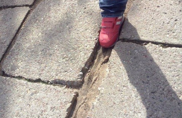 Pakeliui į mokyklą: plytelių tarpuose gali prasmegti visa pradinuko koja