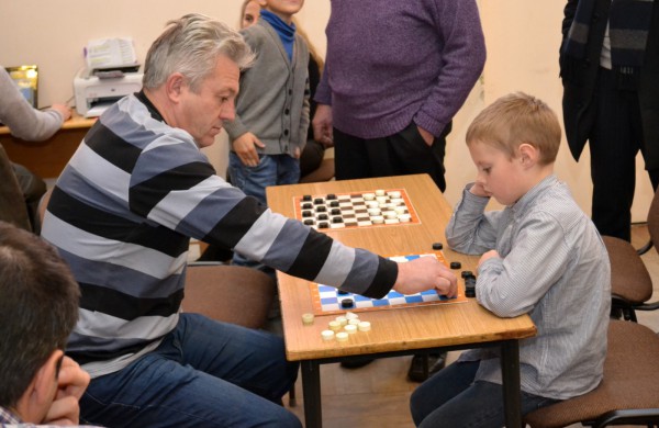 Šeimų laisvalaikis prie šaškių lentų