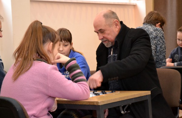 Šeimų laisvalaikis prie šaškių lentų