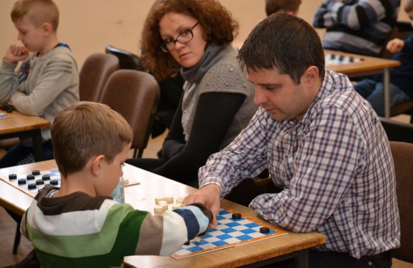 Šeimų laisvalaikis prie šaškių lentų