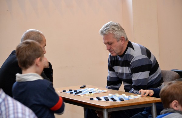 Šeimų laisvalaikis prie šaškių lentų